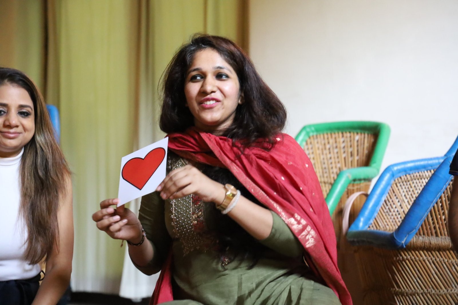 Pooja Grover holding a hand-drawn heart card during a session