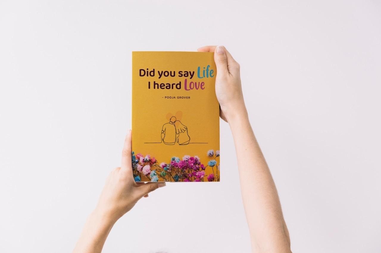 Did You Say Life, I Heard Love by Pooja Grover — front cover held in two hands